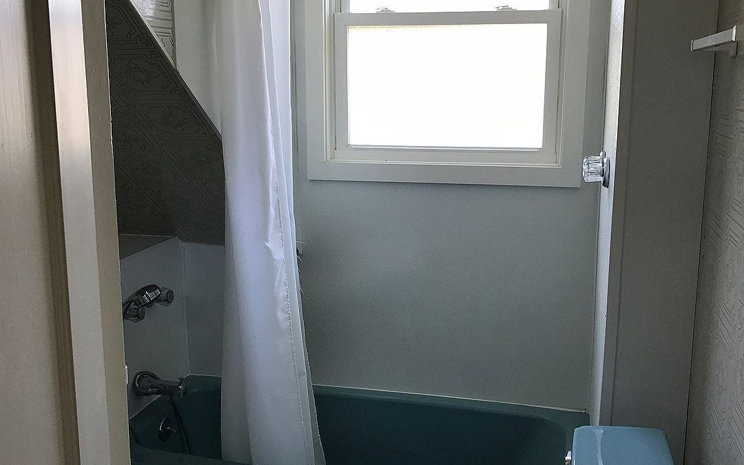 This small, very blue bathroom went from an awkward space to a beautiful bathroom #homerenovation #homeremodel #bathroomremodel #bathroom #bathroomdesign #mainehomedesign #windowview #glassshowerdoor #quartzcountertops #marbletile #benjaminmoorehealingaloe #kohlerfixtures #smallbutbeautiful #portlandmaine #bluebungalowproject #heartenhome